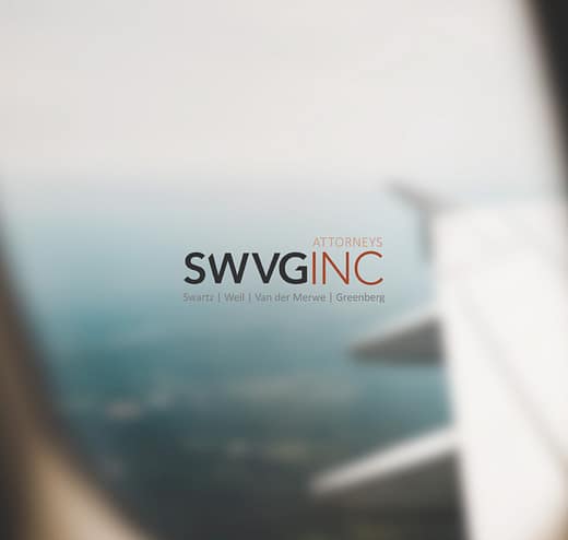 SWVG Inc Attorneys – International Law Airplane wing seen from a window over distant landscape - representing cross-border legal support for contracts, disputes and compliance.