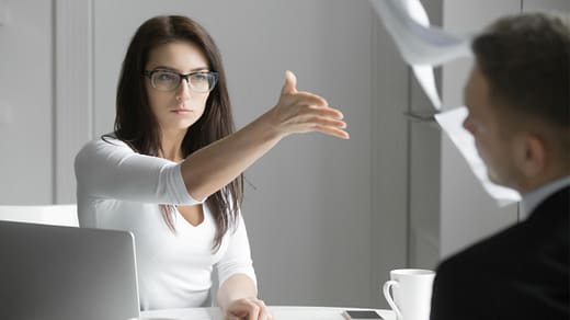 Dispute Resolution & Mediation Specialists – SWVG Inc. Woman assertively tossing legal papers in a tense business meeting, reflecting SWVG Inc.'s dispute resolution services.